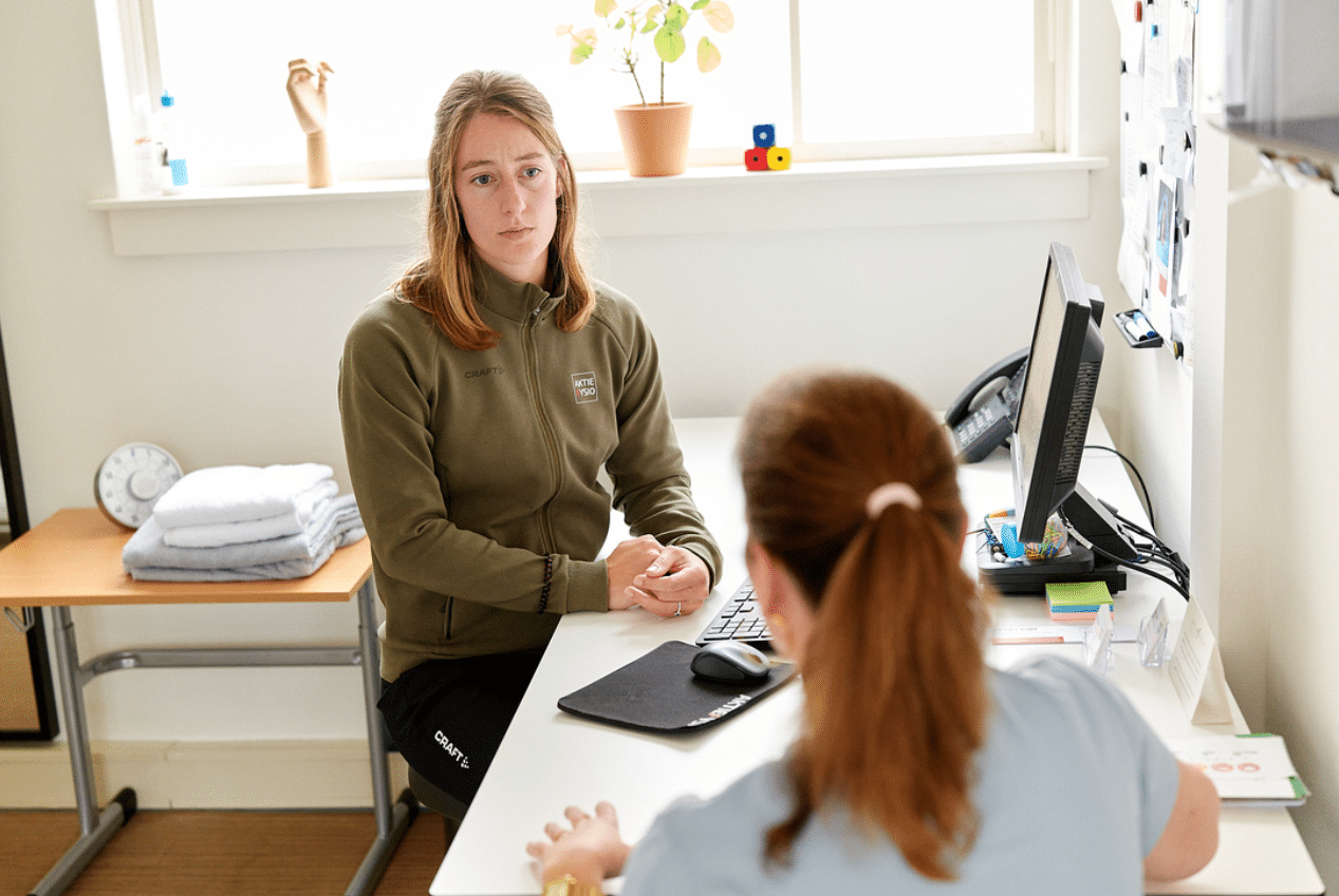 Fysiotherapeut in gesprek met patient