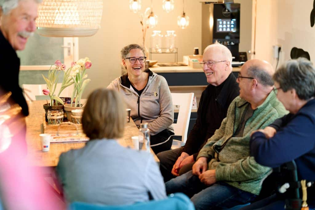 Fysiotherapeut vrouw met groep oudere patienten