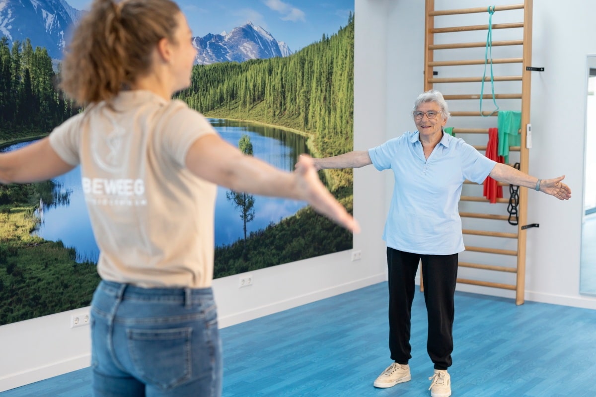 Fysiotherapeut en oudere patient in oefenzaal