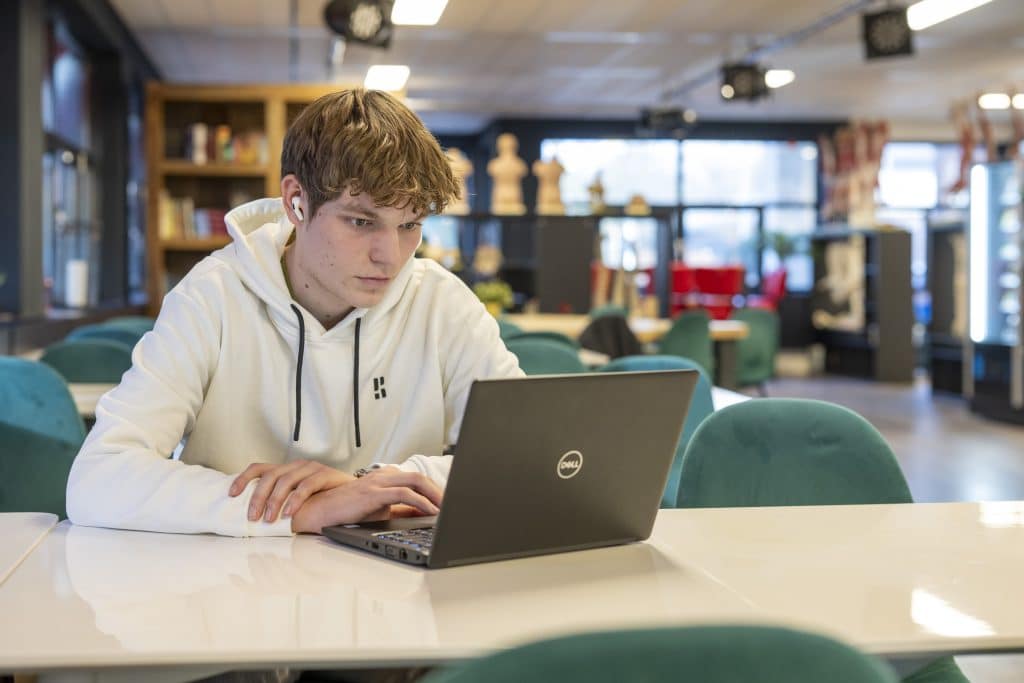 student achter laptop gezicht zichtbaar
