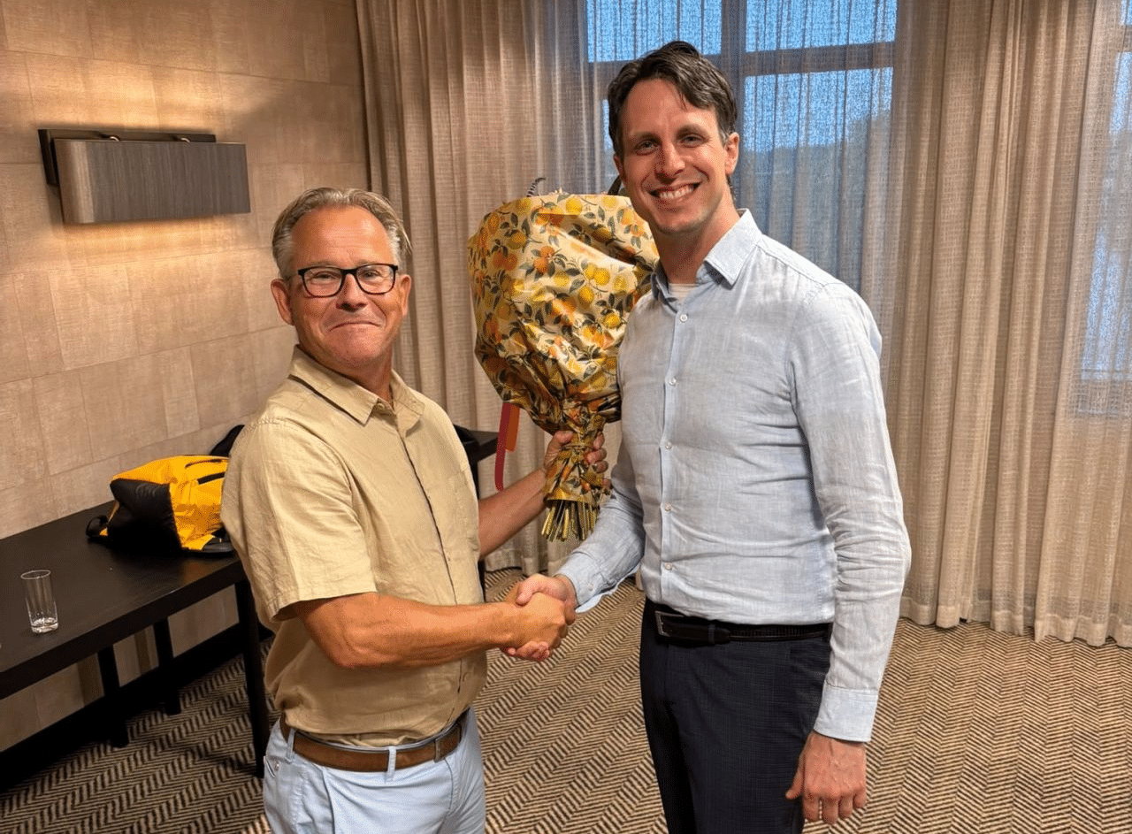 Twee mannen feliciteren met bos bloemen