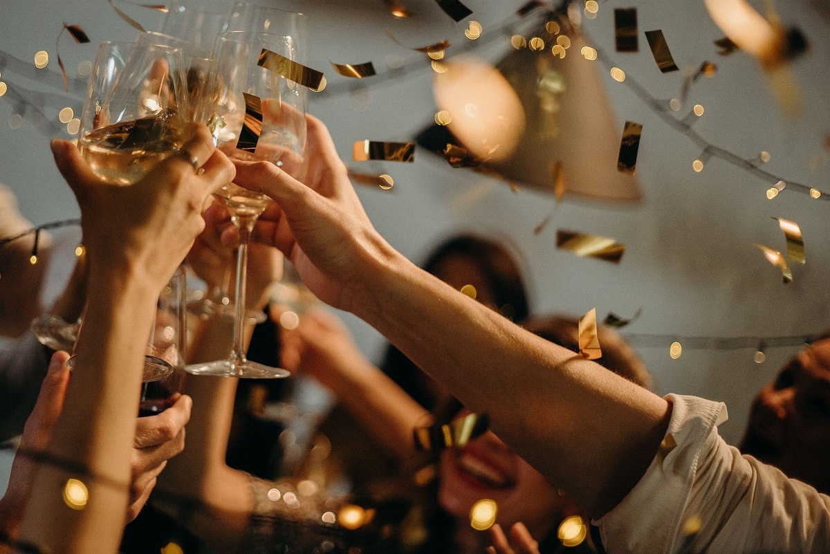 Handen proosten met champagne en glitters